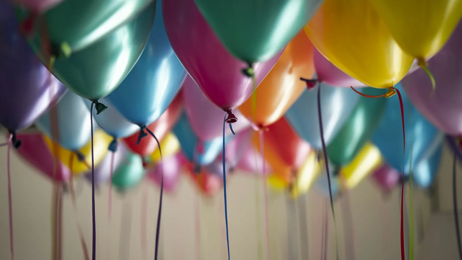 Balões coloridos presos ao teto de um salão de festa