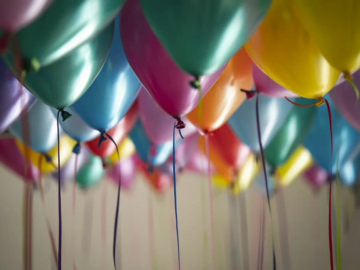 Balões coloridos presos ao teto de um salão de festa