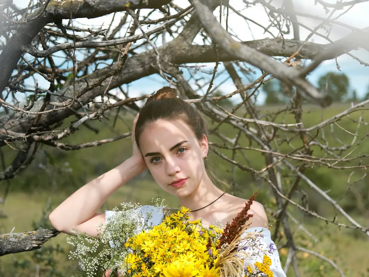 Debutante segurando um buquê de flores amarelas ao ar livre